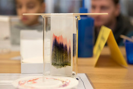 Koordinierte Forschungsprogramme Ein Messglas in dem ein dunkel gefärbter Filter hängt.