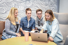 Fachschaft Physik Eine Gruppe mit Laptop sitzt auf Sesseln.