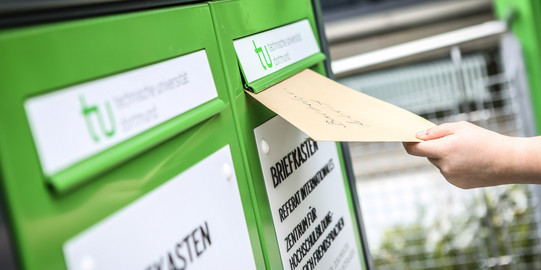 Fristenbriefkasten Eine Hand wirft einen Umschlag in den Fristenbriefkasten